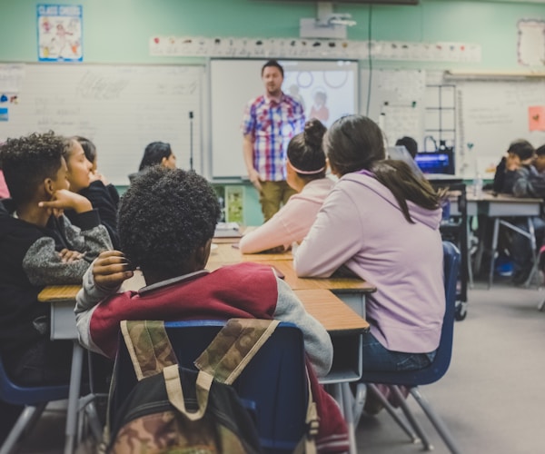 Professional educator teaching students in a modern classroom setting